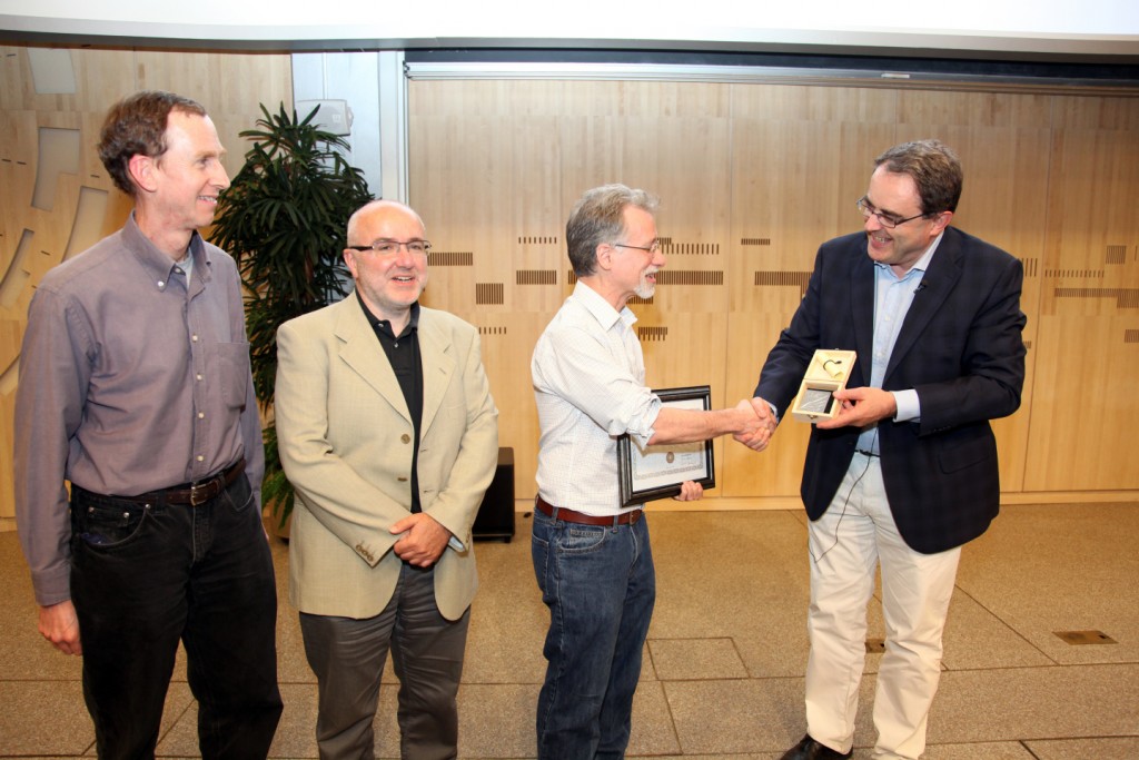 George Alverson receiving his award from, left to right, Bill Gary (UC Riverside), current publications committee co-chair, Roberto Tenchini (Universita di Pisa and INFN), and Tiziano Camporesi (CERN), CMS spokesperson).
