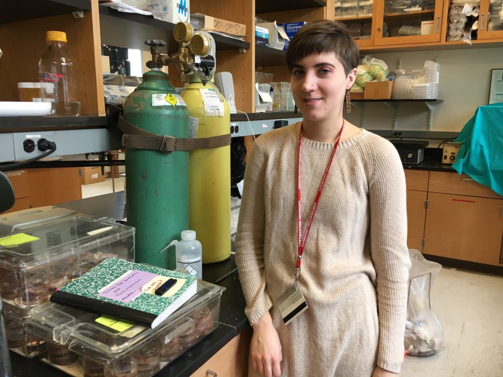 Erin Cole stands in front of a lab bench