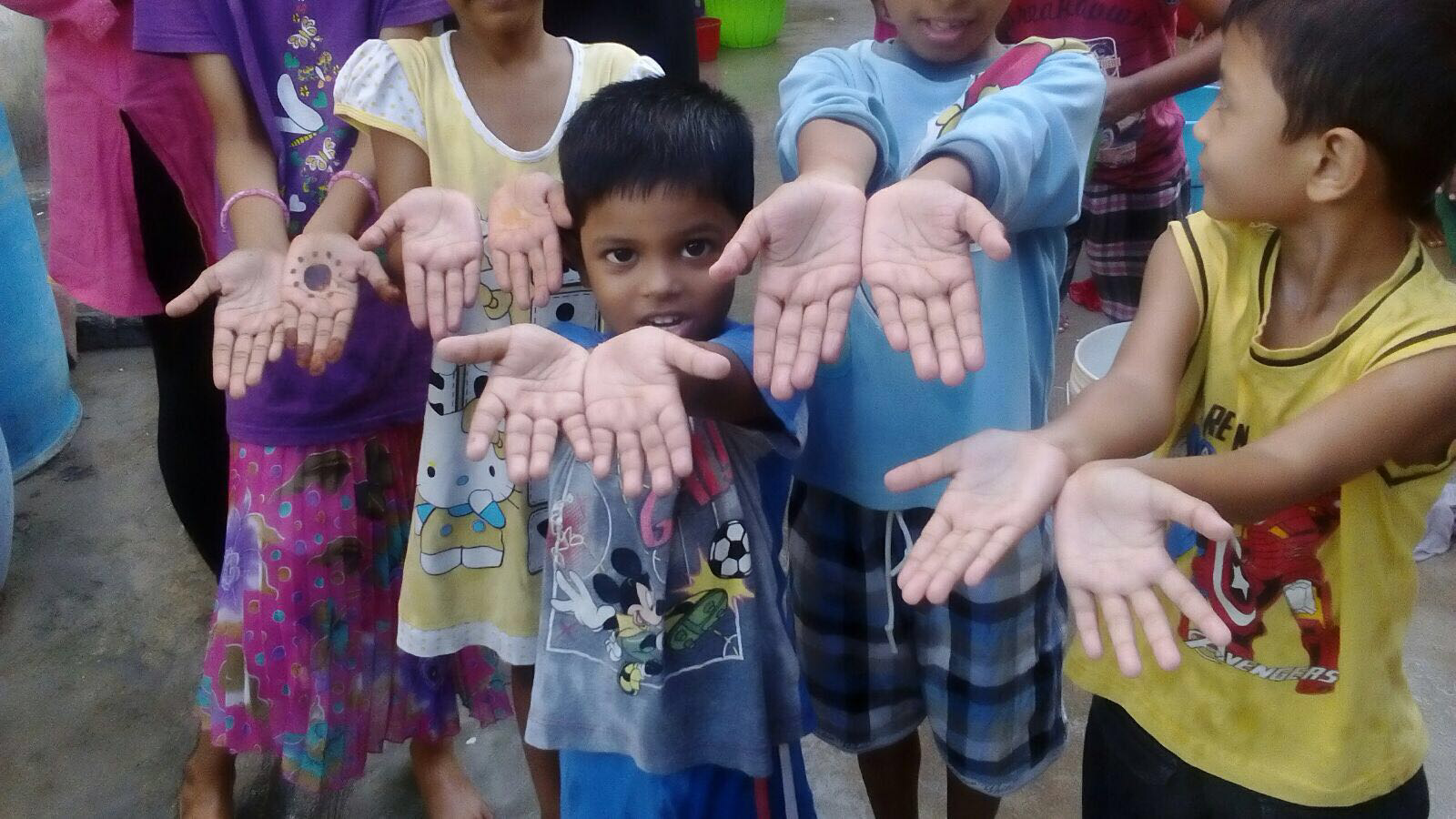 Children show their clean hands after practicing proper hand washing skills.