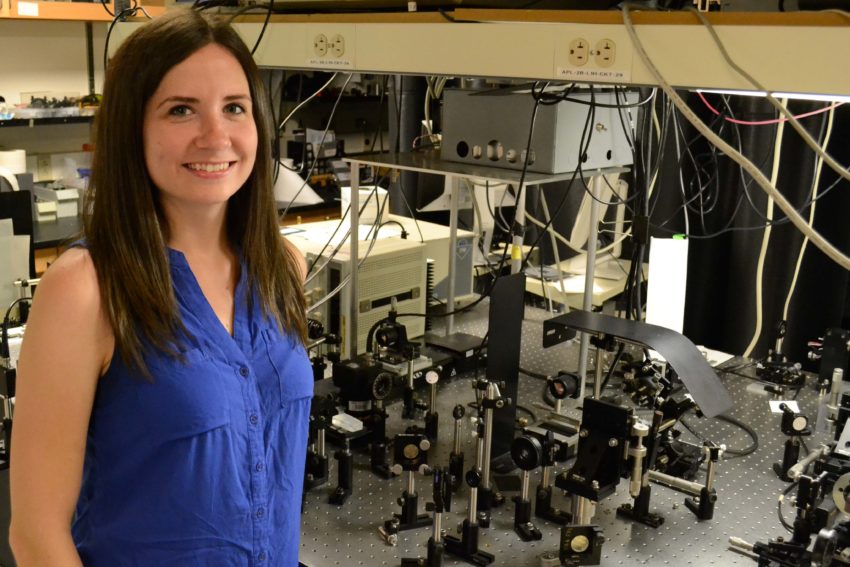 Bridget Salna, physics PhD student, stands in a lab