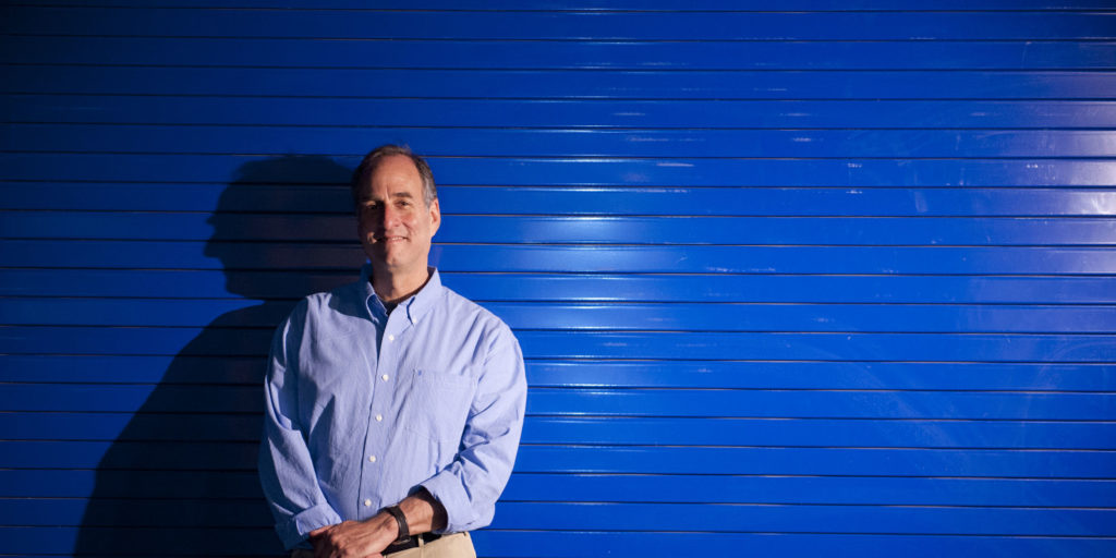 Dan Distel standing in front of blue background