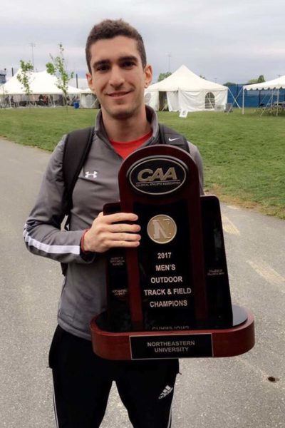Daniel Bassous holding a track and field trophy