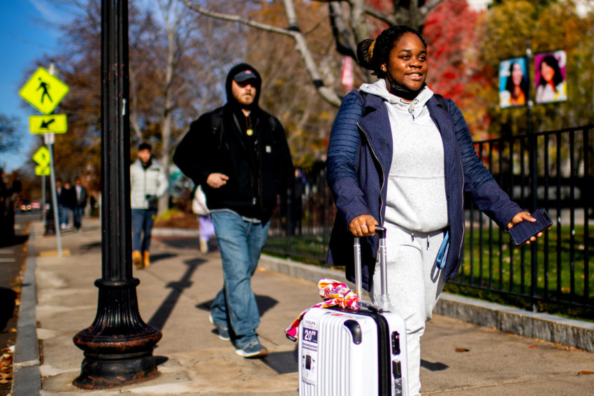 students walking with suitcases in Northeastern campus