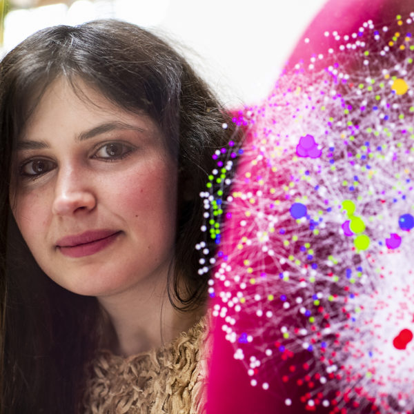 Alessia Iancarelli poses with a digital graphc of the work she has been doing in her lab