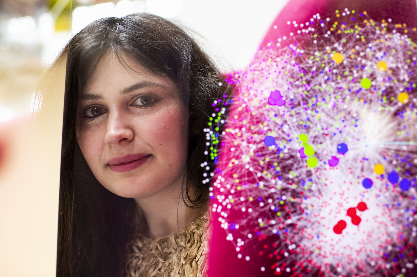 Alessia Iancarelli poses with a digital graphc of the work she has been doing in her lab