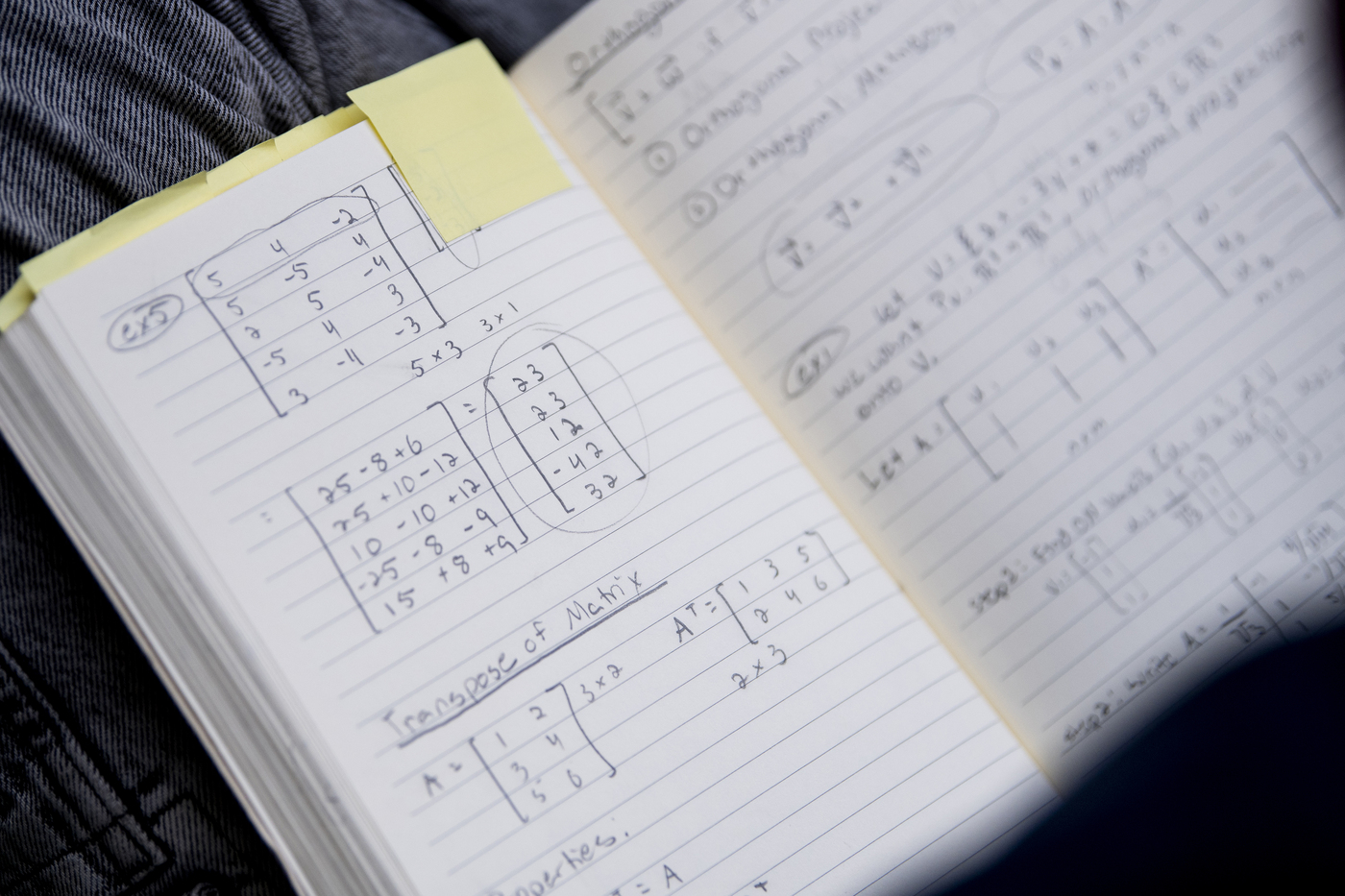 math problems written on a piece of paper within a notebook