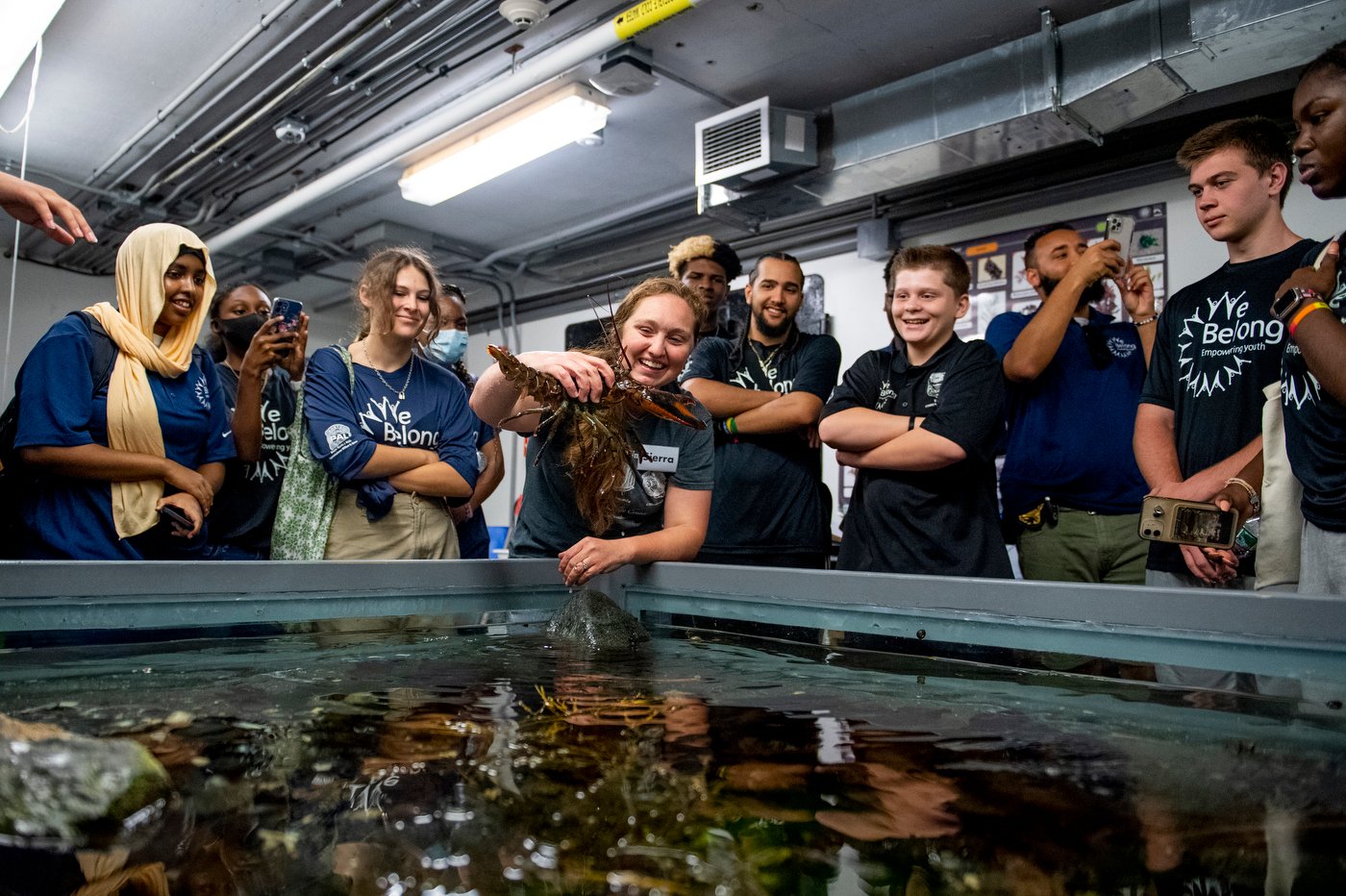 Students from Boston's We Belong hold a lobster
