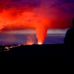 Person watches volcano eruption