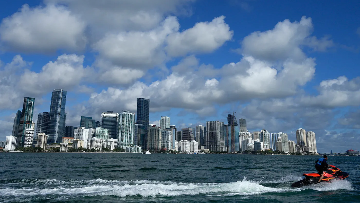 A jet ski rides on the waters of Biscayne Bay past the Miami skyline