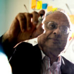 Arun Bansil using a marker to write on a clear glass .