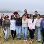 Dr. Jen Bowen poses for a photo at the Marine Science Center with the 13 undergraduates and recent graduates selected from a competitive applicant pool to attend the 2023 BEACHES workshop.