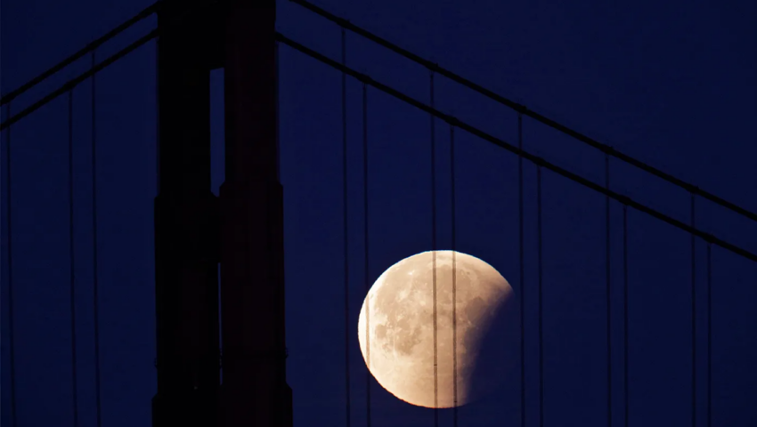 The partially-eclipsed Super Blue Blood Moon makes its way past the Golden Gate Bridge as seen from the San Francisco Yacht Club in San Francisco, Calif., on Wednesday, January 31.