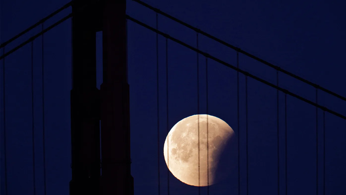 The partially-eclipsed Super Blue Blood Moon makes its way past the Golden Gate Bridge as seen from the San Francisco Yacht Club in San Francisco, Calif., on Wednesday, January 31.