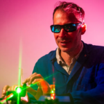 Northeastern Assistant Professor of Physics and Bioengineering Bryan Spring demonstrates how a pulsed laser works in his lab in the Interdisciplinary Science and Engineering Complex.