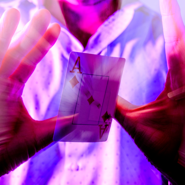 A man holds up his hands while a playing card floats in between them.