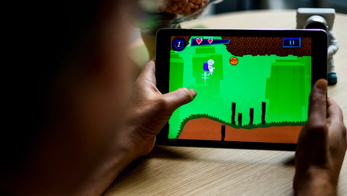 Up close shot of someone's hands on a tablet. The person seems to be playing a game on the tablet.