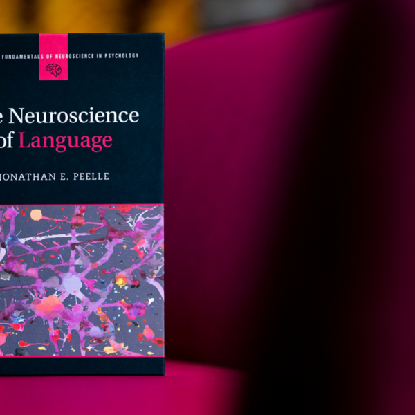 Close up photo of the from of a book titled, "The Neuroscience of Language." Both the book and the background feature a lot of magenta.