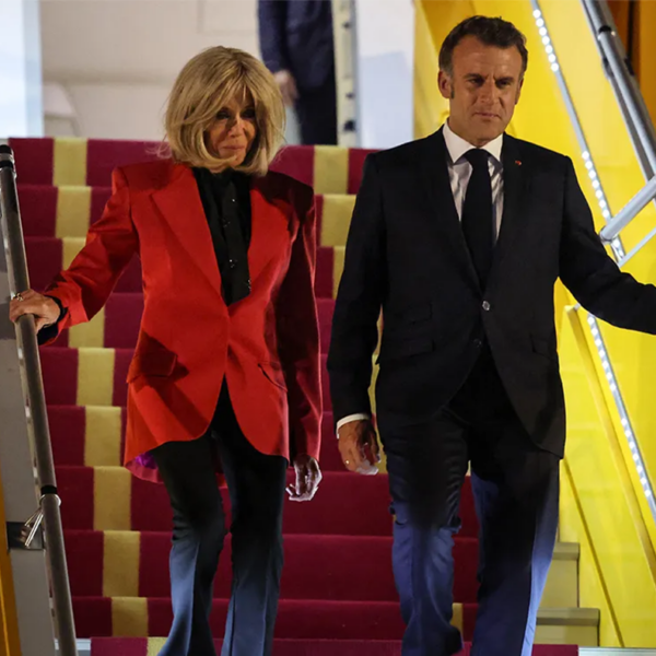 Photo of the Macrons stepping off a plane and down the stairs.