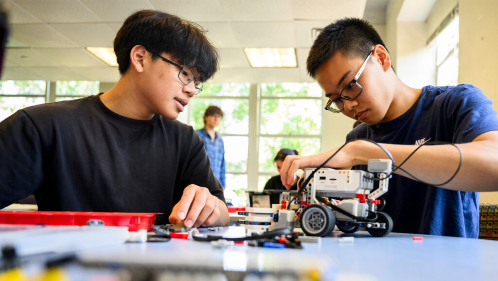 two high school students use legos to apply physics lessons